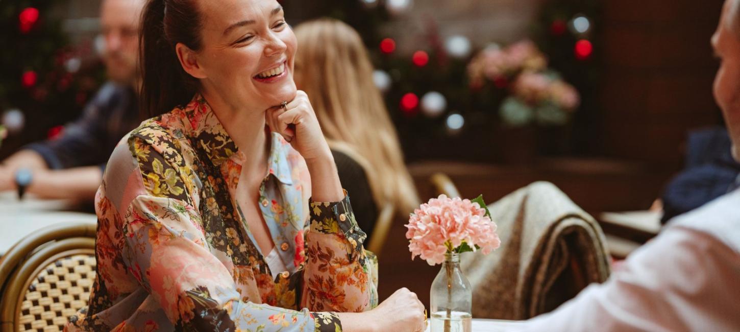 Par sidder ved bord på cafe